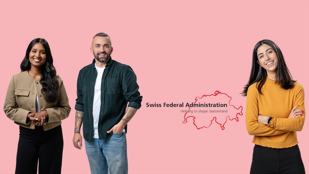 Three people against a pink background, two women and one man; the man wears jeans and a dark shirt, the women wear a beige jacket and a mustard yellow sweater.